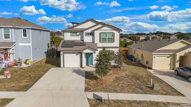 view of front of house featuring concrete driveway, a residential view, fence, board and batten siding, and a front yard