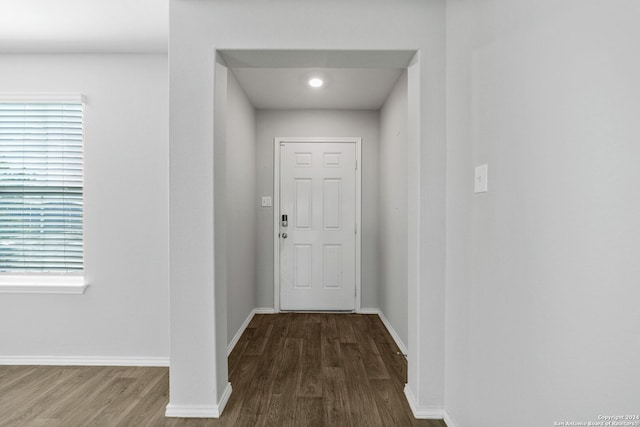 doorway with baseboards and wood finished floors