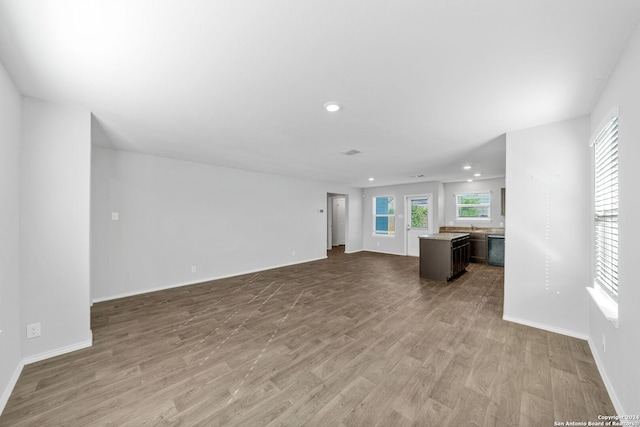 unfurnished living room featuring baseboards, wood finished floors, and recessed lighting