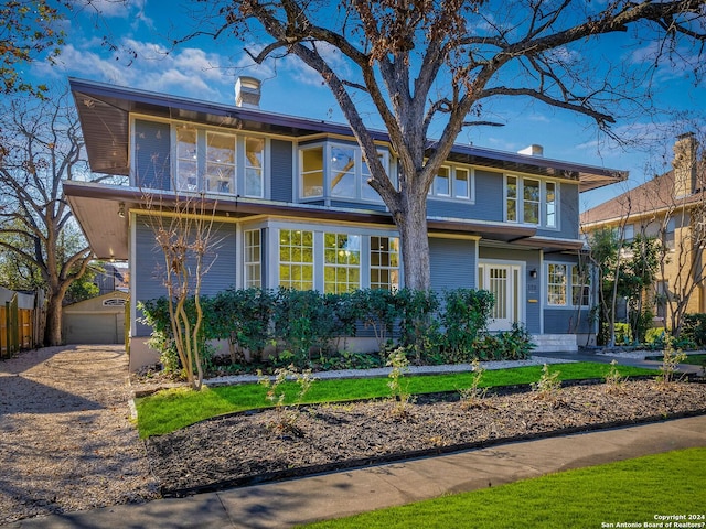 view of front of home featuring a garage, a chimney, and fence