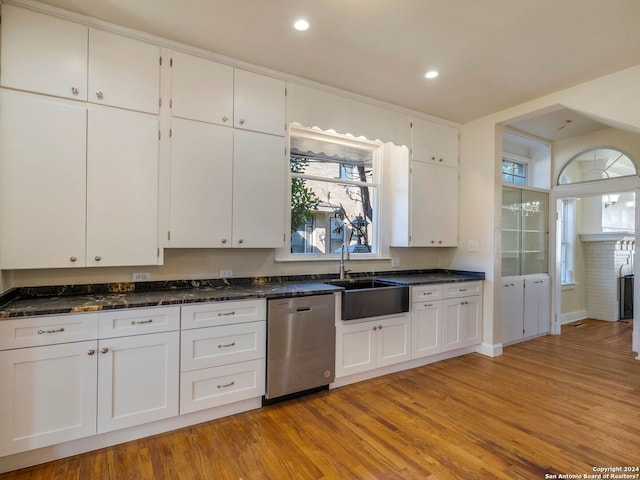 kitchen with a sink, light wood-style floors, white cabinets, and dishwasher