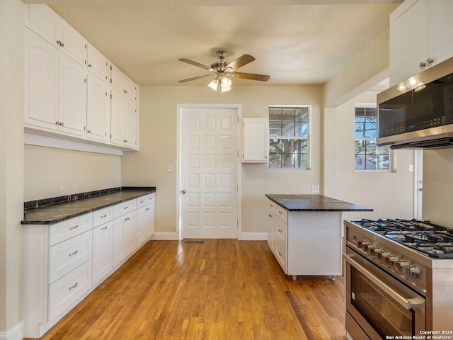 kitchen featuring dark countertops, white cabinetry, and stainless steel appliances