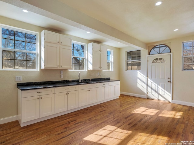 kitchen featuring a sink, light wood-style flooring, and white cabinetry