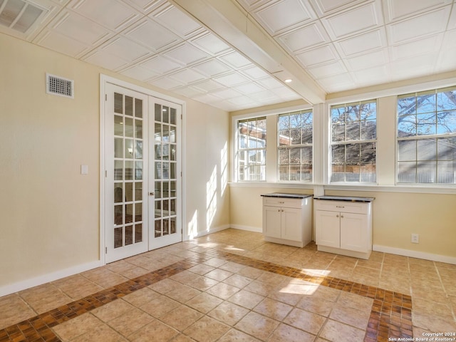 unfurnished sunroom with an ornate ceiling, visible vents, and french doors