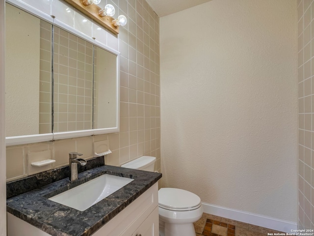 bathroom featuring vanity, toilet, and baseboards