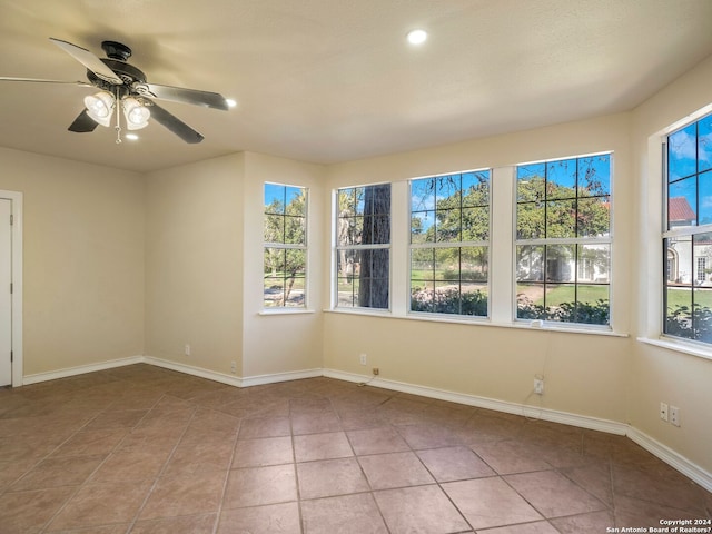 unfurnished room with a wealth of natural light, baseboards, and tile patterned floors