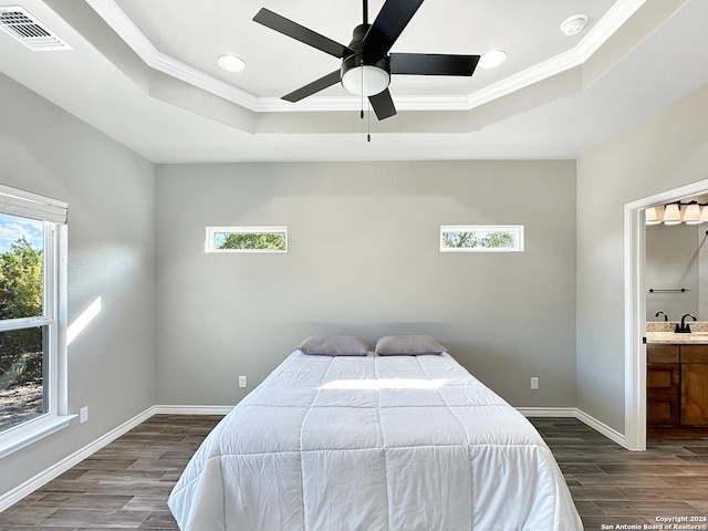 bedroom with a raised ceiling, visible vents, and multiple windows