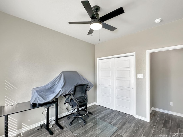 office space with baseboards, ceiling fan, and wood tiled floor