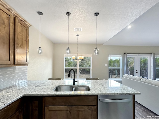 kitchen with visible vents, decorative backsplash, a peninsula, a sink, and stainless steel dishwasher