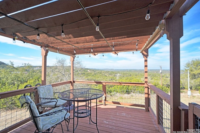 deck featuring a forest view and outdoor dining space