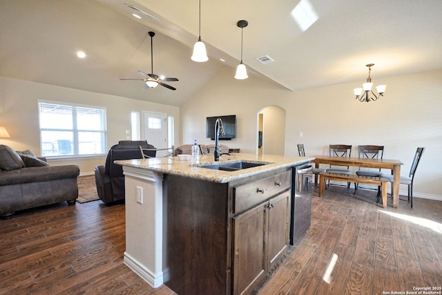 kitchen featuring dark wood-type flooring, arched walkways, open floor plan, and visible vents