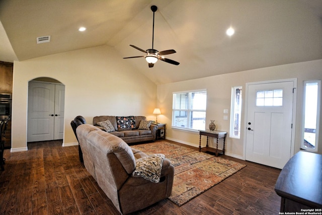 living room with arched walkways, visible vents, vaulted ceiling, and wood finished floors