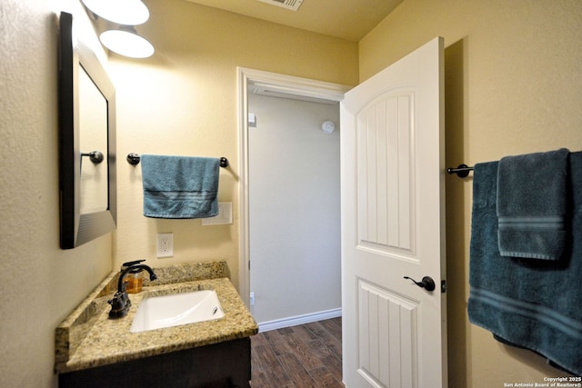 bathroom with wood finished floors, vanity, and baseboards