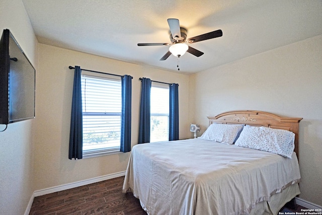 bedroom featuring ceiling fan, dark wood finished floors, and baseboards