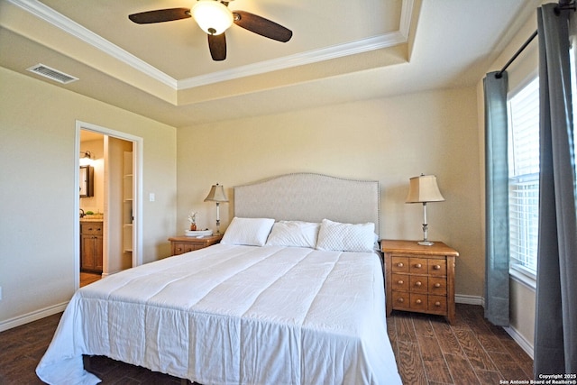 bedroom with a raised ceiling, visible vents, ornamental molding, wood finished floors, and baseboards