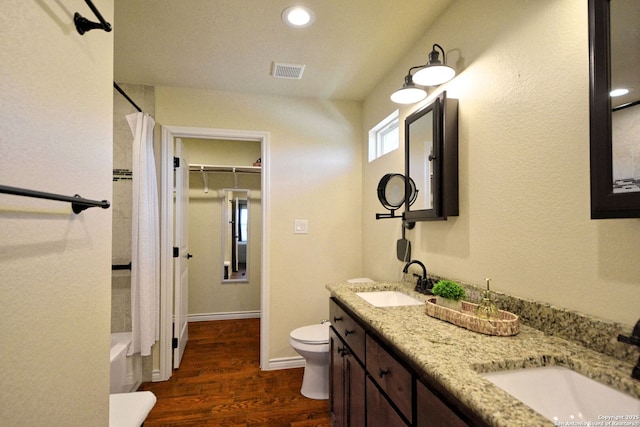 bathroom with toilet, visible vents, a sink, and wood finished floors