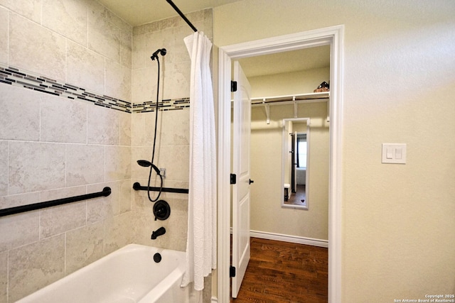 bathroom with shower / bath combo, wood finished floors, and baseboards