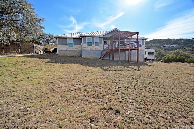 exterior space with a lawn, a standing seam roof, metal roof, a wooden deck, and stairs