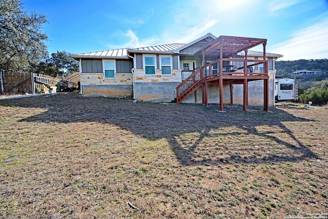 rear view of property featuring stairway, metal roof, a standing seam roof, fence, and board and batten siding