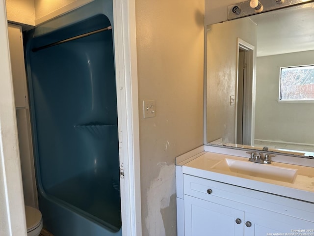 full bathroom featuring a bath, vanity, and toilet