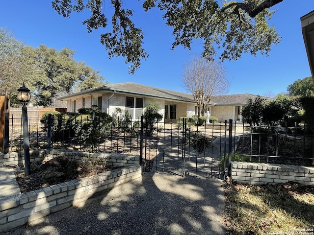 ranch-style home featuring a gate, fence, and brick siding