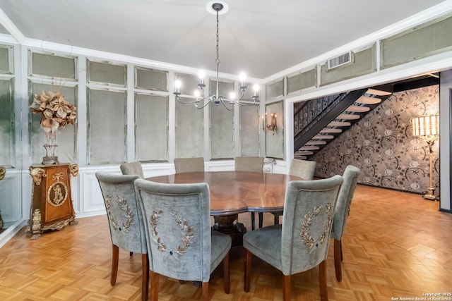 dining area with stairs, visible vents, a decorative wall, and a notable chandelier