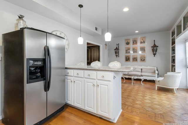 kitchen with recessed lighting, light countertops, white cabinetry, a peninsula, and stainless steel fridge with ice dispenser