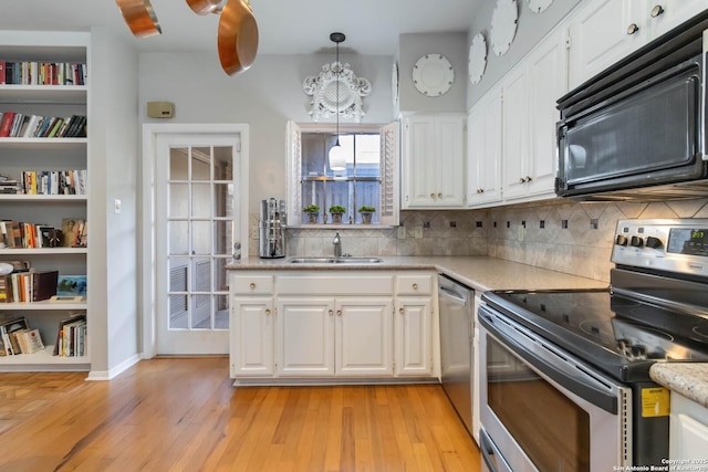 kitchen featuring stainless steel appliances, light countertops, light wood-style flooring, and white cabinets