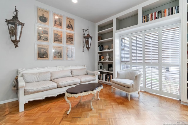 sitting room with built in shelves and baseboards