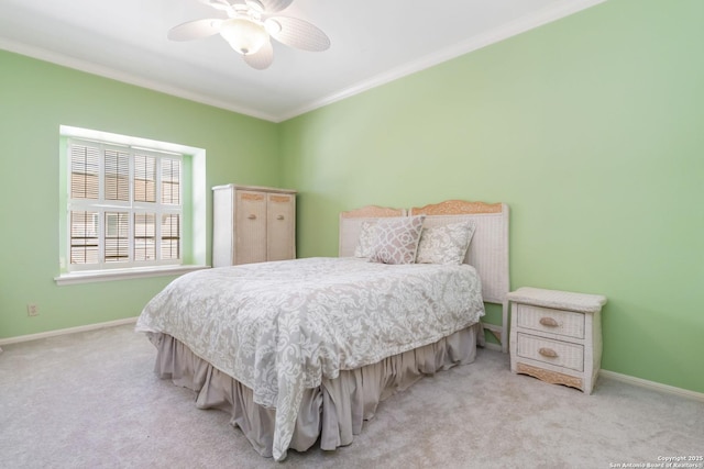 carpeted bedroom with baseboards, ornamental molding, and a ceiling fan