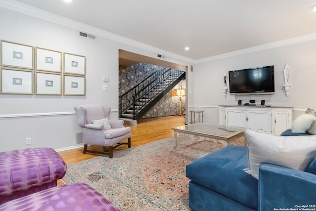 living area with recessed lighting, wood finished floors, visible vents, stairs, and ornamental molding