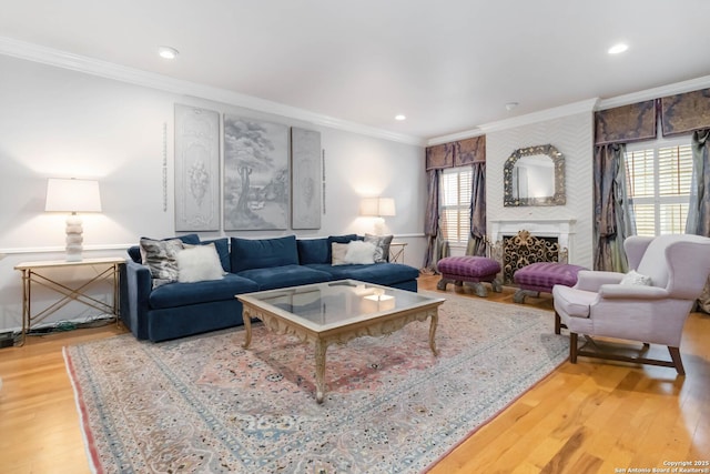 living room with ornamental molding, recessed lighting, a fireplace, and wood finished floors