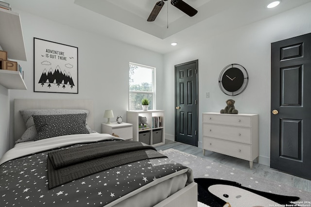 bedroom featuring recessed lighting, a raised ceiling, ceiling fan, wood finished floors, and baseboards