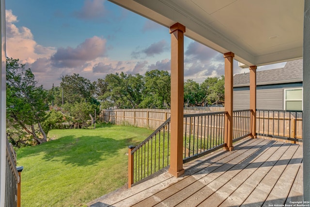 wooden deck featuring a yard and fence