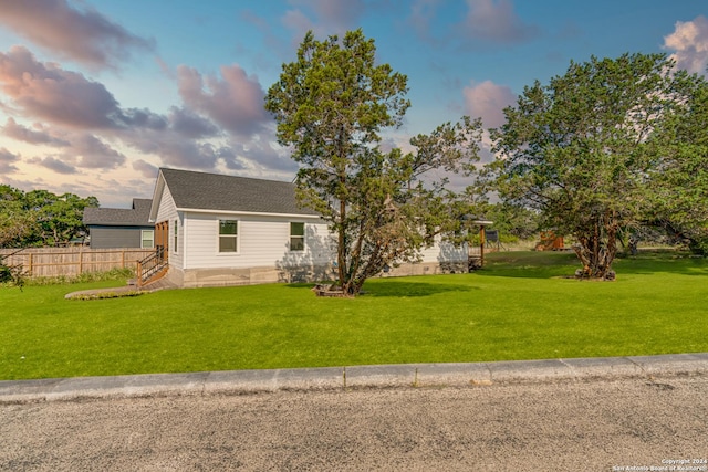 view of front of home featuring fence and a front lawn