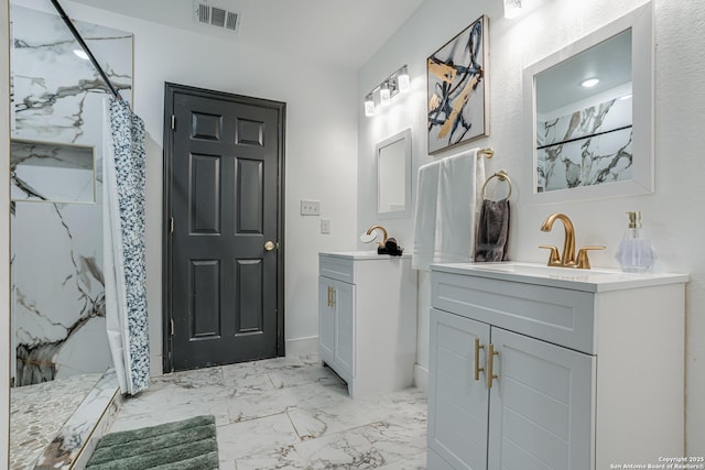 bathroom with marble finish floor, a marble finish shower, visible vents, and a sink