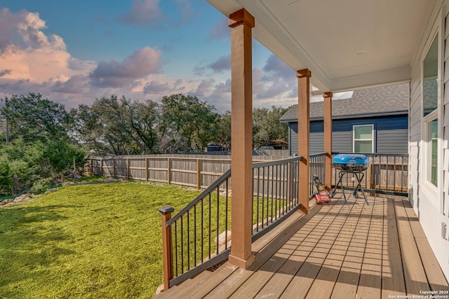 deck featuring a yard, fence, and a grill