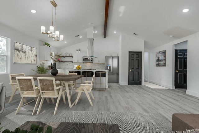 kitchen featuring island range hood, light countertops, backsplash, beam ceiling, and stainless steel fridge