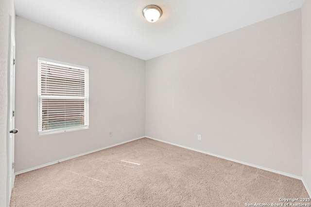 carpeted spare room featuring baseboards