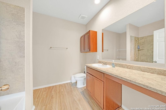 full bathroom with a shower, toilet, vanity, wood finished floors, and baseboards