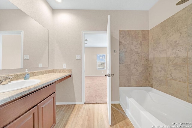 bathroom featuring vanity, baseboards, and wood finished floors