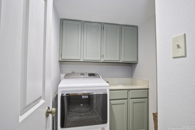 laundry area featuring cabinet space, washer / clothes dryer, and a textured wall