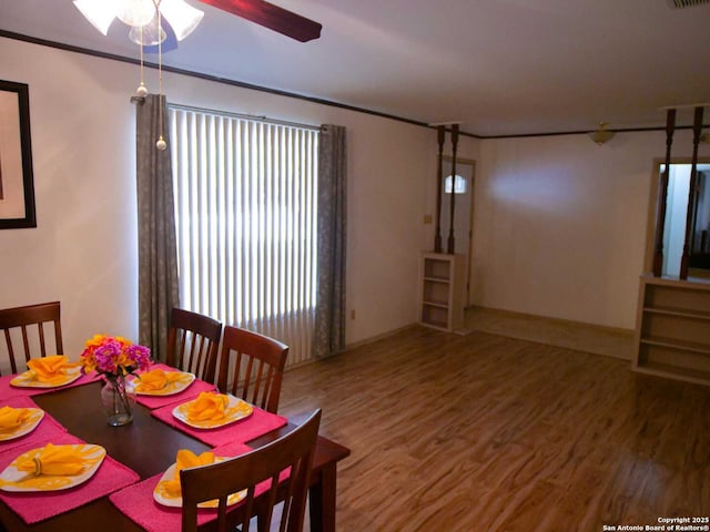 dining space with crown molding, visible vents, ceiling fan, and wood finished floors