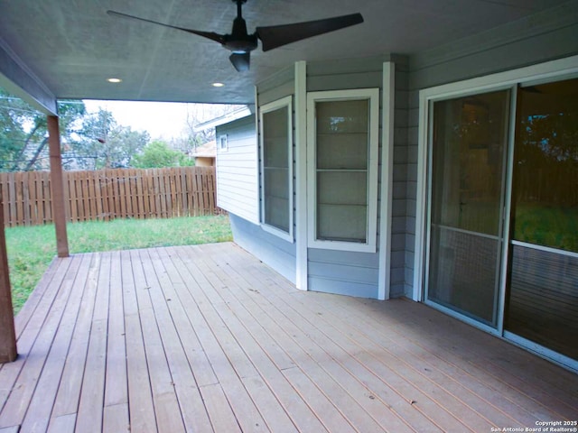 wooden deck with a ceiling fan and fence