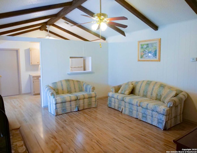 living area with ceiling fan, visible vents, light wood-style flooring, and vaulted ceiling with beams