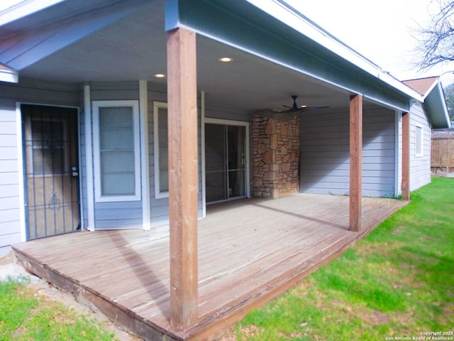 deck featuring a ceiling fan and a yard