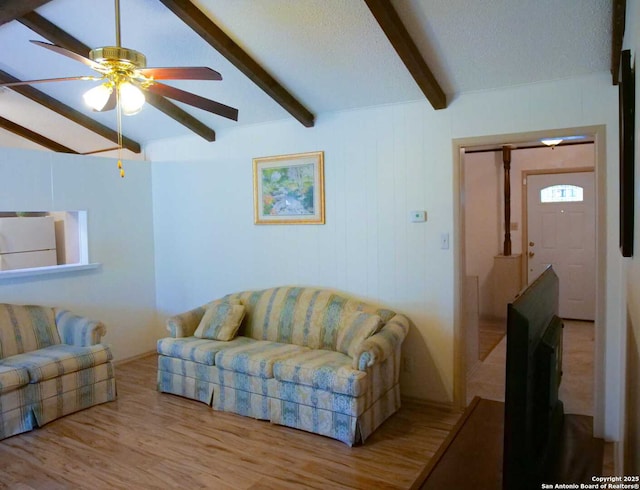 living room featuring ceiling fan, lofted ceiling with beams, wood finished floors, and a textured ceiling