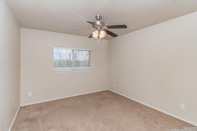 spare room with carpet floors, ceiling fan, baseboards, and a textured ceiling