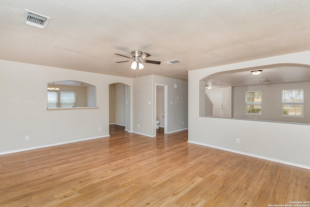 spare room with a ceiling fan, visible vents, light wood-style flooring, and baseboards