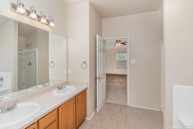 bathroom featuring a ceiling fan, a stall shower, a sink, and double vanity